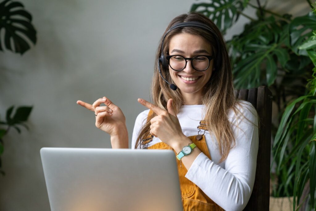 Smiling gardener millennial woman wear headphones talk video calling using laptop communicating with t20 e0b4gx.jpg